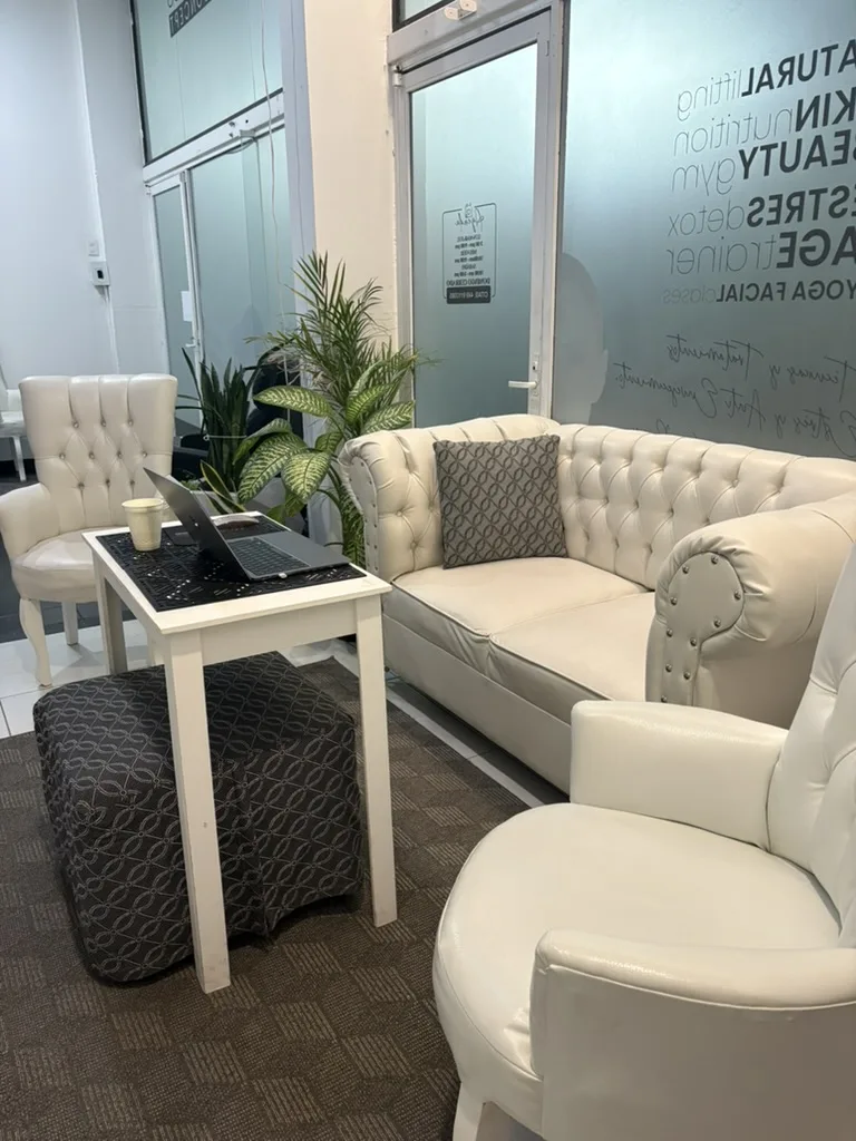 Sala de espera con sillones amplios y plantas del spa